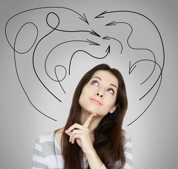 18969696 - young woman thinking and looking up with many arrows above the head on grey background