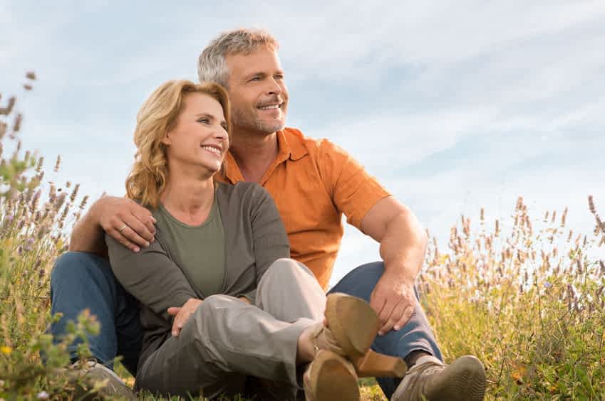 31178930 - portrait of a happy mature couple sitting in field and contemplate the future